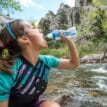 Kvinna som dricker ur Katadyn BeFree vattenflaska med filter 0,6 liter vattenrening.