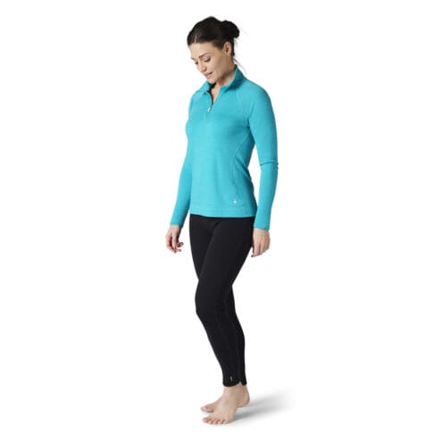 Kvinna som bär varm underställströja i färgen Capri från Merino 250 Base Layer Crew från Smartwool.