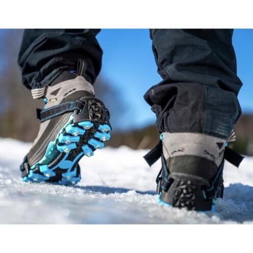 Miljöbild på person som går med Nordic grip extreme broddar i snö.