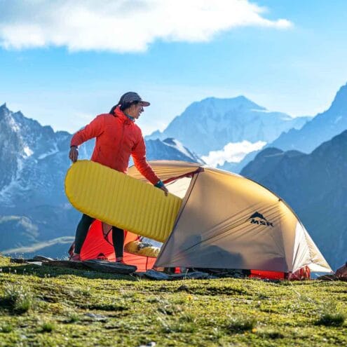 en person lägger in en Therm-a-Rest NeoAir XLite NXT uppblåsbart liggunderlag i tältet