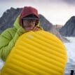 en person blåser upp Therm-a-Rest NeoAir XLite NXT uppblåsbart liggunderlag