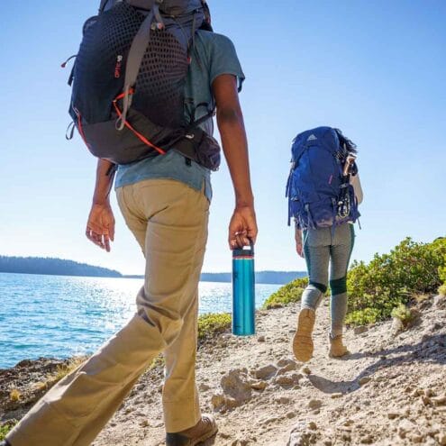 En person med Hydro Flask Lightweight Wide Mouth Trail Series 24oz / 709 ml i handen på en promenad