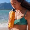 En person som använder Hydro Flask Standard Flex Straw Cap munstycke.
