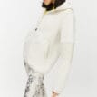 Röhnisch Wazzi Pile Hoodie, på en brunhårig modell som står åt sidan