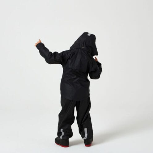 En pojke har påp sig Tretorn Kids Packable rainset och står och dansar