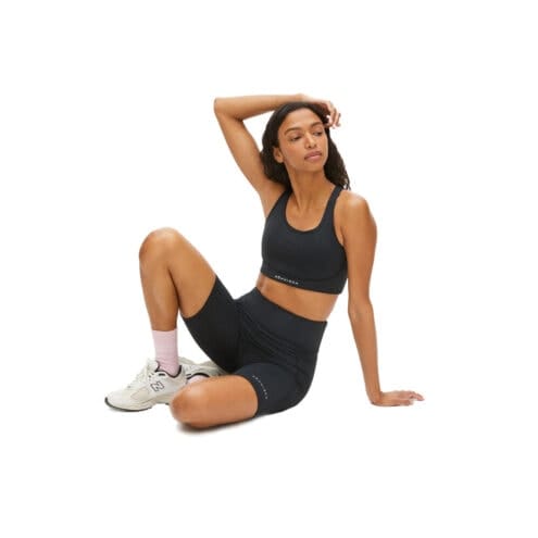En modell som sitter ner och har på sig Röhnisch Flattering High Waist Bike Tights
