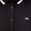 Närbild på knäppning och logga på J.Lindeberg Moira Polo retro pikétröja (dam)