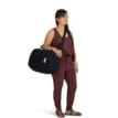 en person använder en Osprey Arcane Duffel Pack 22L väska (unisex) som axelväska