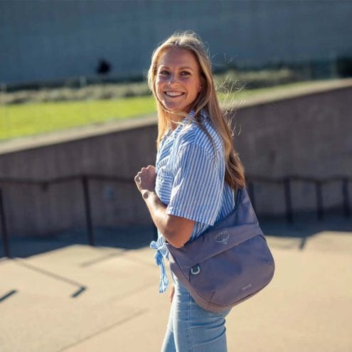 en lila Osprey Daylite Crossbody Pouch axelväska (unisex) på en modell