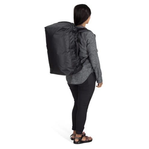 en modell har Osprey Transporter Squffel 44L resväska (unisex) på ryggen