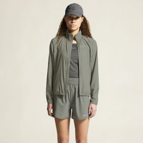 en kund bär en grön Craft Core Essence Wind Jacket vindjacka (dam)