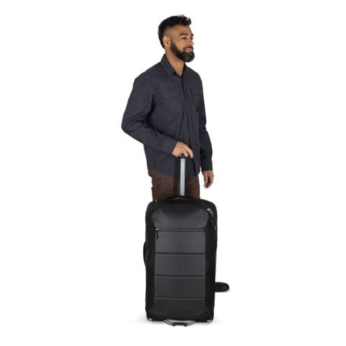 en man använder en Osprey Ozone 2-Wheel 80L resväska (unisex)