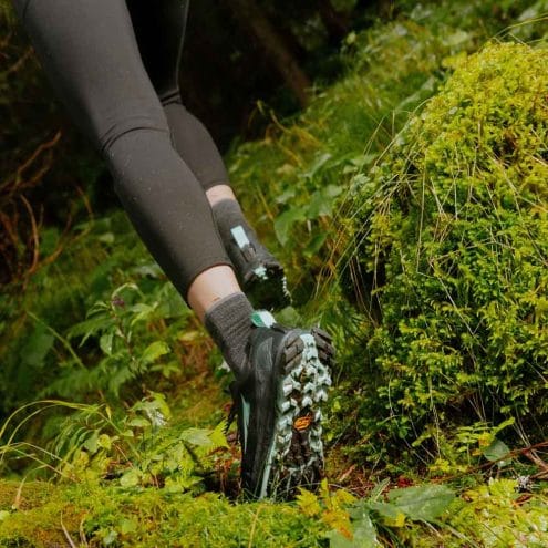 en modell använder Altra Lone Peak 9+ traillöparskor (dam) i en skog
