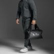 en man håller en 2XU Gym Bag träningsväska (unisex)