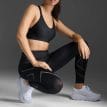 en modell visar upp ett par 2XU Light Speed Mid-Rise Compression Tights träningstights (dam)