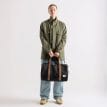 en kvinnlig modell bär Herschel Novel Carry On Duffle väska 26,5 L (unisex)