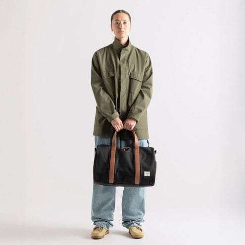 en kvinnlig modell bär Herschel Novel Carry On Duffle väska 26,5 L (unisex)