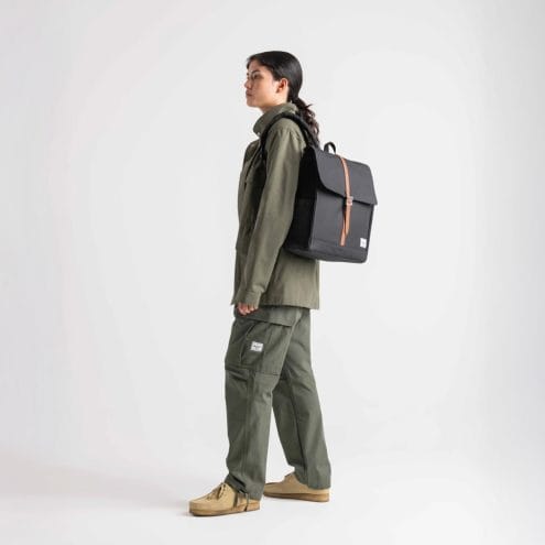 en kvinna bär Herschel City vardagsryggsäck 16 L (unisex)